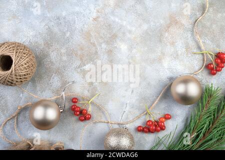 Weihnachtsspielzeug mit Luftballons und rotem Viburnum auf grauem Hintergrund. Stockfoto