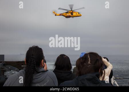 An Bord eines Kriegsschiffs von der Canadian Forces Base in Esquimalt, British Columbia, beobachtet eine Gruppe von Frauen eine Such- und Rettungsdemonstration eines Ch Stockfoto