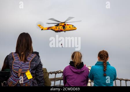 An Bord eines Kriegsschiffs von der Canadian Forces Base in Esquimalt, British Columbia, beobachtet eine Gruppe von Frauen eine Such- und Rettungsdemonstration eines Ch Stockfoto