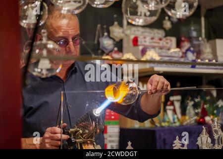 glaskrabber formt, bläst, flackiert und macht am Stand auf dem Weihnachtsmarkt in Düsseldorf ein wunderschönes Glaskunstwerk Stockfoto