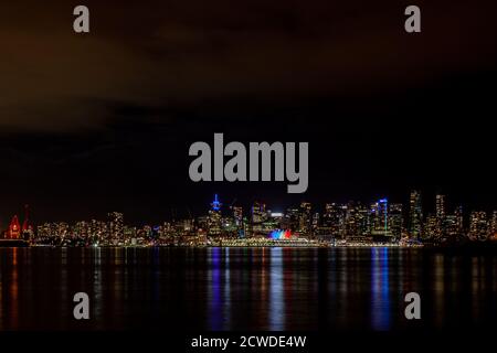 Ein Blick auf die Innenstadt von Vancouver mit den Segeln des Canada Place, der in Pride-Farben erstrahlt, aufgenommen vom Lonsdale Quay in North Vancouver Stockfoto