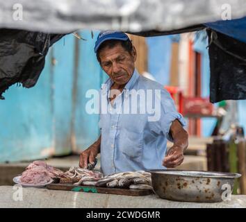 Puerto Pizarro, Ecuador - 20.August 2014: Mann bereitet frisch gefangenen Fische Stockfoto
