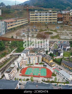 (200929) -- SHIZHU, 29. September 2020 (Xinhua) -- OBEN: Das von der lokalen Regierung zur Verfügung gestellte Aktenfoto zeigt eine Luftaufnahme der Zhongyi Township Primary School im Autonomen Bezirk Shizhu Tujia, südwestlich der chinesischen Chongqing Gemeinde im Jahr 2013.UNTEN: Das Luftbild vom 8. April 2020 zeigt die gleiche Schule nach der Renovierung. (Foto von Liu Chan) die Gemeinde Zhongyi in Chongqing hatte eine hohe Armutsrate aufgrund der schlechten Bodenqualität und des unbequem Transports in einem bergigen Gelände. Vor 2018 gingen mehr als 60 Prozent der Arbeitskräfte im Dorf Huaxi in andere Städte, um dort zu arbeiten Stockfoto