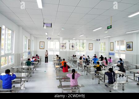 (200929) -- SHIZHU, 29. September 2020 (Xinhua) -- Schüler essen im Speisesaal der Zhongyi Township Primary School im Shizhu Tujia Autonomous County, südwestlich von Chongqing Gemeinde, 8. Mai 2020. Zhongyi Gemeinde in Chongqing hatte eine hohe Inzidenz von Armut aufgrund schlechter Bodenqualität und unbequem Transport in einem bergigen Gelände. Vor 2018 gingen mehr als 60 Prozent der Arbeitskräfte im Dorf Huaxi in andere Städte, um ihren Lebensunterhalt zu verdienen, was fast 60 Prozent des Ackerlandes unbebaut ließ. Doch die Bemühungen zur Armutsbekämpfung begannen, Hua Veränderungen zu bringen Stockfoto