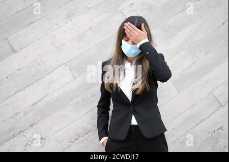 Kranke junge Geschäftsfrau trägt Gesichtsmaske,. Kranke Arbeitnehmerin mit Coronavirus, Grippe-Infektion Symptom Konzept. Hochwertige Fotos Stockfoto