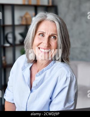 Glücklich schöne alte Geschäftsfrau lächelnd Blick weg im Büro. Stockfoto