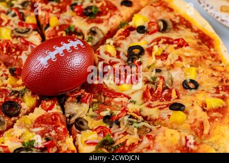 Pepperoni Supreme Pizza mit Fußball für american Football Party. Stockfoto
