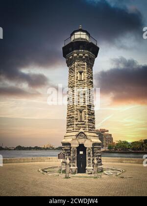 Roosevelt Island Lighthouse auch bekannt als Blackwell oder Welfare. Leuchtturm aus Steinen. Blick bei stürmischem Sonnenuntergang Stockfoto