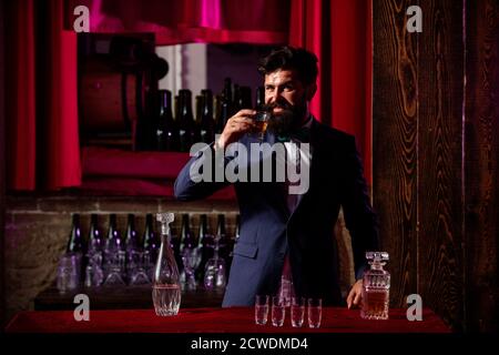 Der Barkeeper bereitet einen Cocktail zu. Macho trinken. Stilvoller reicher Mann mit einem Glas alten Whisky. Gentleman trinken Cognac oder Whiskey. Stockfoto