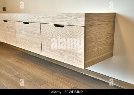 Moderne Möbel. Wandschrank aus Holz mit Schubladen im modernen Schlafzimmer Stockfoto