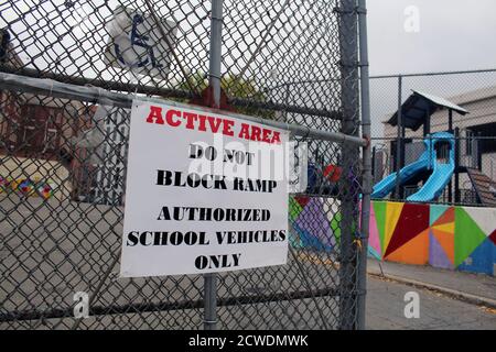 New York, New York, USA. September 2020. Die Glocke läutete an der 6 Public School in der Bronx, wo die Kinder nach sechs Monaten der Schließung wie 300,000 Grundschüler in New York City zur Schule zurückkehrten. Ein Schild, das für das Parken von Schulfahrzeugen vorgesehen war, hing an dem Zaun der Schule, die gerade ihre Türen wieder geöffnet hat. Dennoch konnte die Rückkehr zur Schule wieder in Frage gestellt werden, da die Covid-19 in mehreren Bezirken wieder auftauchte. Darüber hinaus bestreiten viele Eltern und Lehrer das vom Bürgermeister Bill de Blasio ins Leben gerissene Schulprogramm, weil sie glauben, dass die Gesundheitsmaßnahmen nicht sicher genug sind Stockfoto