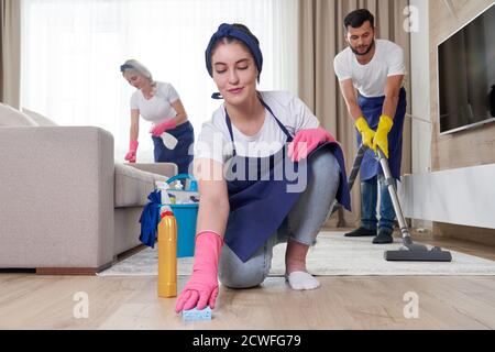 Professionelles Reinigungsservice-Team reinigt Wohnzimmer in modernen Wohnung Stockfoto