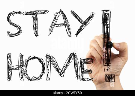 Bleib zu Hause Phrase auf einem Whiteboard, geschrieben mit schwarzem Marker in einer Hand. Stockfoto