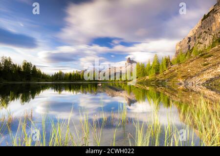 Wolken bei Sonnenaufgang über Rifugio Croda da Lago und Becco di Mezzodi spiegeln sich im Federasee, Ampezzo Dolomiten, Venetien, Italien Stockfoto