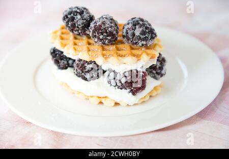 Goldene Waffeln mit Brombeeren und Frischkäse Stockfoto