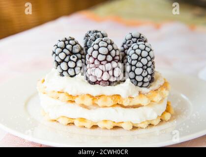 Goldene Waffeln mit Brombeeren und Frischkäse Stockfoto