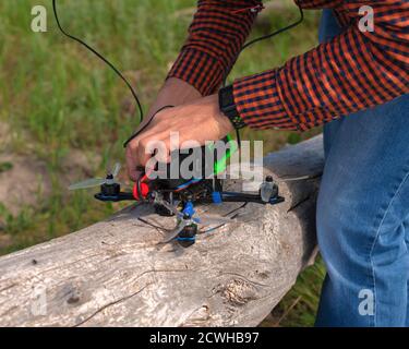 Mann repariert und justiert eine Renndrohne vor dem Fliegen Stockfoto