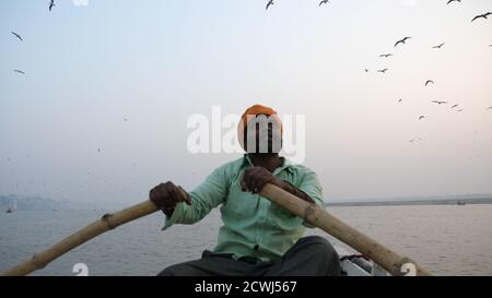Varanasi, Indien - 18. Dezember 2017: Am frühen Morgen auf dem Ganga-Fluss schwimmend. Bootsmann Rudern. Stockfoto