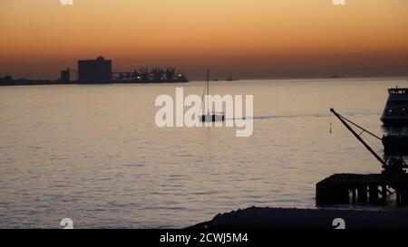 Boot schwimmt bei wundervollem Sonnenuntergang. Stockfoto