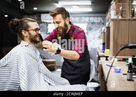 Kunden bei Bart rasieren im Friseurladen Stockfoto