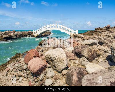 Shimen, Taiwan - 3. Oktober 2016: Eine weiße Brücke zwischen den Felsen am Ufer des Ozeans in Shimen Art, Nordtaiwan Stockfoto