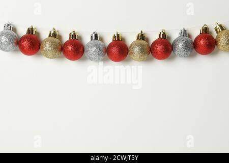 Weihnachtskugeln hängen an einer Schnur auf weißem Hintergrund Stockfoto