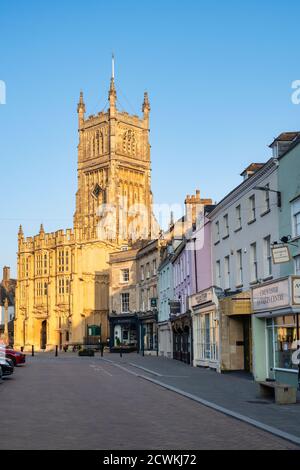 Die Kirche von St. Johannes dem Täufer vom Marktplatz bei Sonnenaufgang im Herbst. Cirencester, Cotswolds, Gloucestershire, England Stockfoto