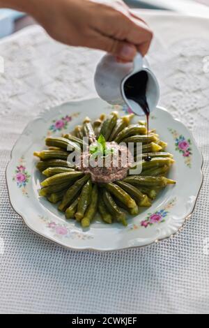 Geschmorte Okra mit gemahlenem Fleisch und Granatapfelsirup Stockfoto