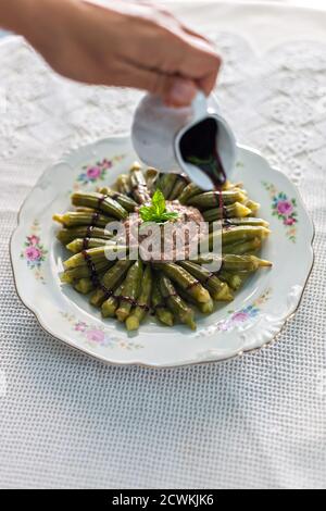 Geschmorte Okra mit gemahlenem Fleisch und Granatapfelsirup Stockfoto