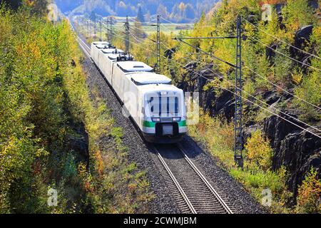 Express-Zug, der an einem schönen Tag durch die herbstliche Landschaft Finnlands fährt, mit einer erhöhten Aussicht. Stockfoto