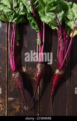 Rote Bete mit Spitzen auf einem hölzernen Hintergrund Overhead-Ansicht Stockfoto