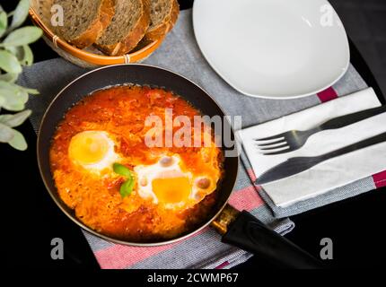 Shakshuka - ein Eiergericht, in Tomaten, Paprika und Zwiebeln gebraten. Essen zum Frühstück mit Brot oder Pita Stockfoto
