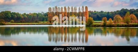 Bäume und Wolken Spiegelungen auf einem Teich im Herbst, Panorama-Landschaft in Burgund, Frankreich Stockfoto