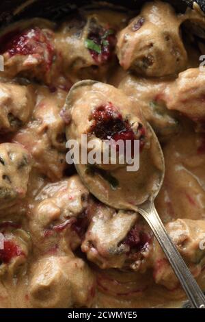 Skandinavisches, komfortables Essen. Hausgemachte Fleischbällchen in Soße mit saurer Beerensauce aus nächster Nähe Stockfoto
