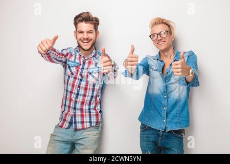 Zwei glückliche junge Männer, die den Daumen nach oben machten Handbewegung im Studio Stockfoto