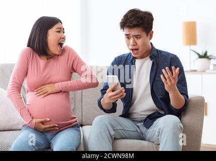 Schockiert Asiatische Ehemann Ruft Notfall Für Schwangere Frau Zu Hause Stockfoto