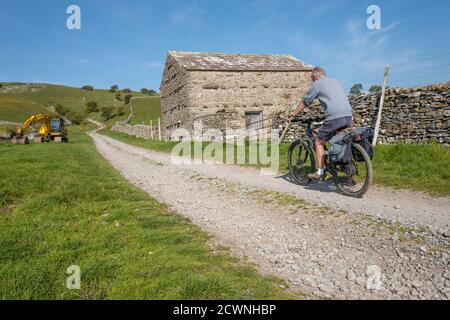 Mountainbiker, die entlang einer Brücke in den Yorkshire Dales, England, Großbritannien, reiten Stockfoto
