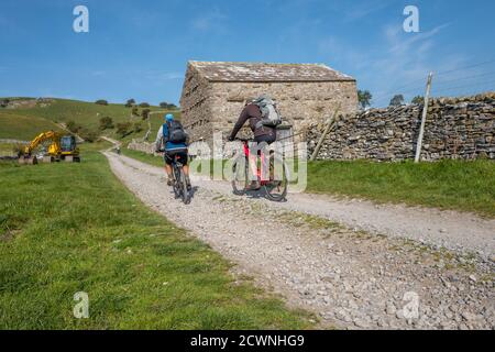 Mountainbiker, die entlang einer Brücke in den Yorkshire Dales, England, Großbritannien, reiten Stockfoto