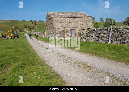 Mountainbiker, die entlang einer Brücke in den Yorkshire Dales, England, Großbritannien, reiten Stockfoto