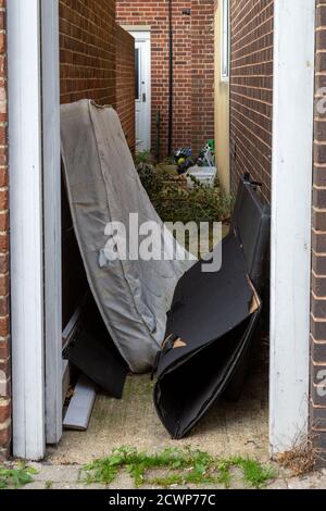 Eine Matratze und andere Hausmüllfliege kippte oder kippte In einer Gasse Stockfoto