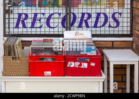 Vinyl-Schallplatten zum Verkauf außerhalb eines Plattenladens mit einem schilder im Hintergrund Stockfoto