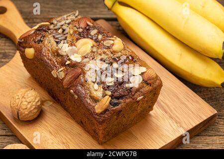 Nahaufnahme Bananenkuchen werden auf einem Holztablett auf einem Holztisch mit Bananen als Hintergrund platziert. Stockfoto