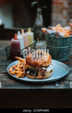 Hamburger mit Pommes auf einer Metallplatte Stockfoto