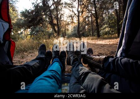 Blick von innen auf Gruppen-Camper liegen im Zelt mit Herbstwald Hintergrund Stockfoto