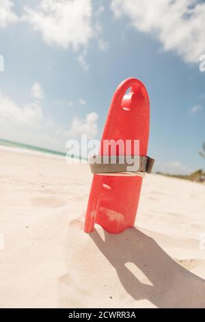 Bild eines roten Plastikröhrchens, am Strand. Stockfoto