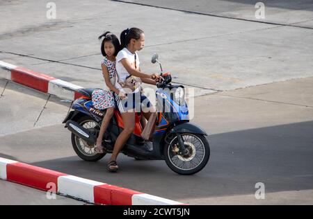 SAMUT PRAKAN, THAILAND, JUNI 26 2020, EINE Frau fährt Mädchen auf einem Motorrad. Eine Mutter fährt mit ihrer Tochter einen Roller. Stockfoto