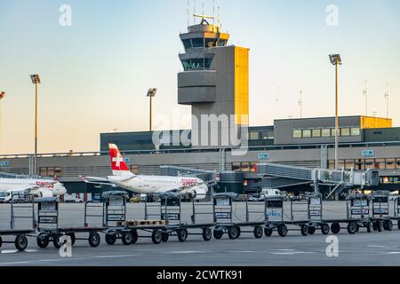 ZÜRICH, SCHWEIZ, JULI 30 2020, EINE Linie von Trolleys für den Transport von Passagiergepäck mit dem Flugzeug, auf dem Hintergrund des Flughafens Zürich. Stockfoto