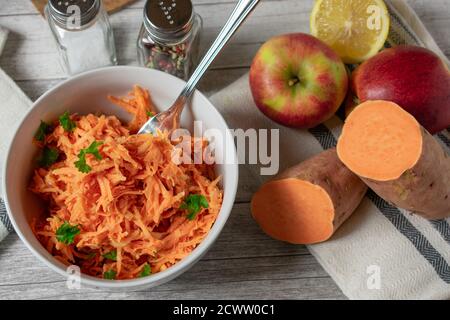 Frischer roher Gemüsesalat in einer Schüssel geraspelte Süßkartoffeln Mit Äpfeln Stockfoto