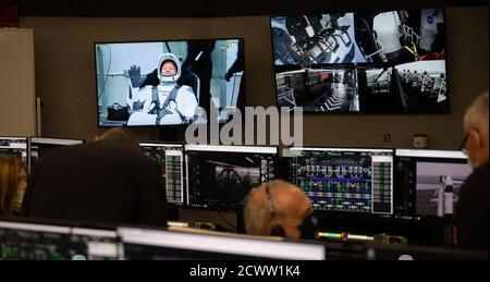 SpaceX Demo-2 Startversuch NASA-Astronaut Douglas Hurley wird während eines Anzugs am Neil A. Armstrong Operations and Checkout Building während eines Startversuchs einer SpaceX Falcon 9 Rakete mit der Crew Dragon Raumsonde der NASA auf der SpaceX Demo-2-Mission gesehen, wie sie auf einem Monitor im Schussraum vier winkt Mit den NASA-Astronauten Hurley und Robert Behnken an Bord, Mittwoch, 27. Mai 2020, im Launch Control Center des NASA Kennedy Space Center in Florida. Die NASA-Mission SpaceX Demo-2 ist der erste Start mit Astronauten der Raumsonde SpaceX Crew Dragon und der Falcon 9-Rakete zur Internation Stockfoto