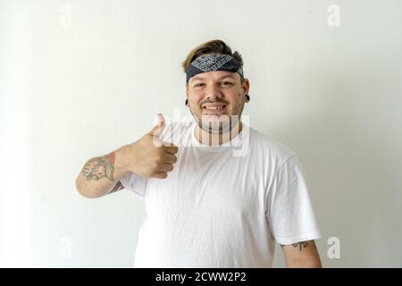 Cool Kerl mit einem schwarzen Bandana auf dem Kopf während Lächelnd und mit Daumen nach oben Stockfoto